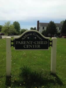 Sign on a lawn outside a building; the sign says Addison County Parent Child Center