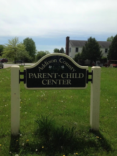 Sign on a lawn outside a building; the sign says Addison County Parent Child Center