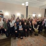 Members of the SAC and BBF staff standing and smiling with a faded antique rug in the foreground