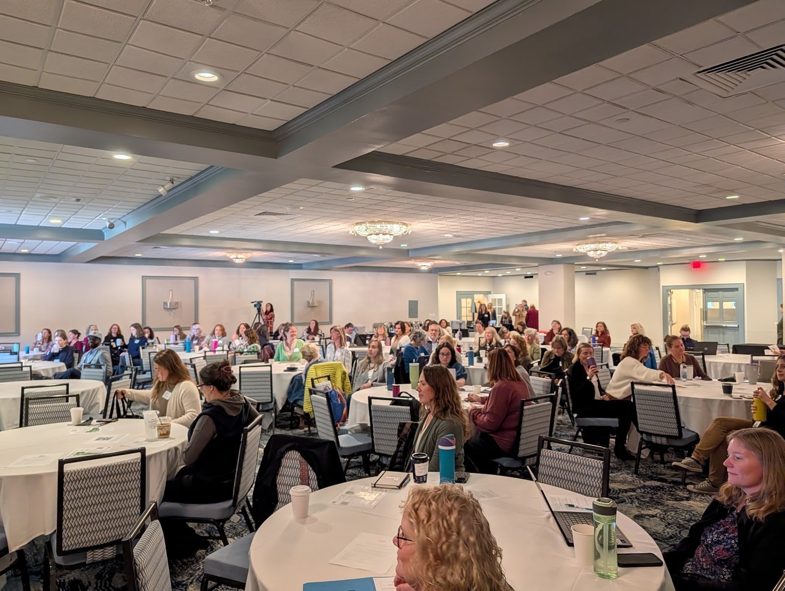 Many people seated at round tables in a conference room at the 2025 Regional Council Summit