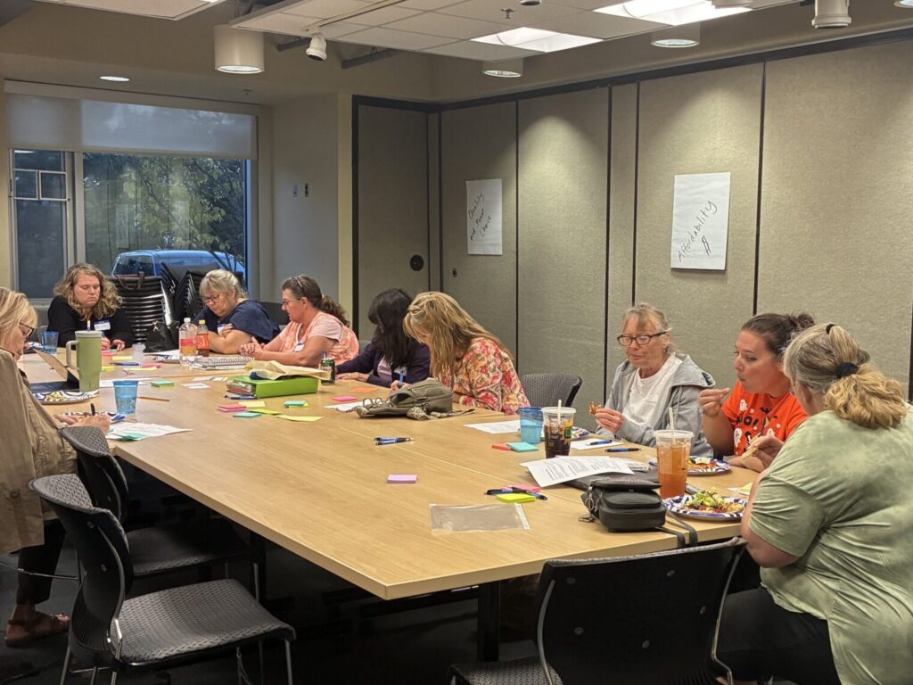 Participants in BBF's 2025 Child Care Conversations sitting around a table, writing