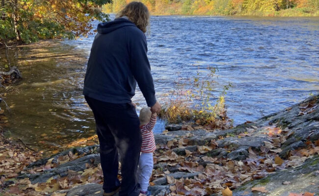 Parent and small child by river